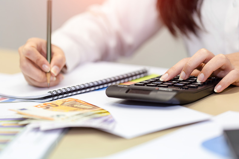 女商人在家查看利润文件,计算并记录数据成本图片下载