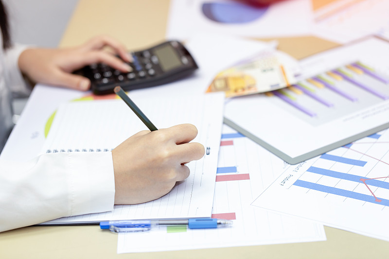 女商人在家查看利润文件，计算并记录数据成本图片下载