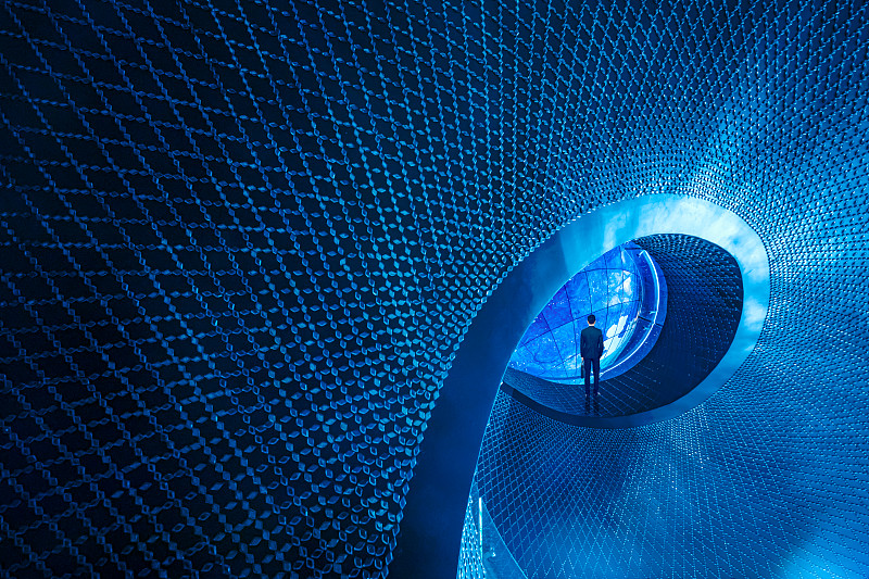 一个穿商务装的男士站在蓝色螺旋顶端看星空背景的背影图片下载