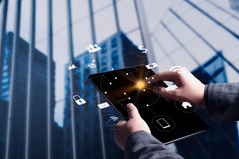 手持平板使用AR应用检查相关信息。城市在营销街道的背景概念图片下载