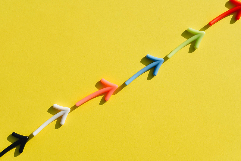 在黄色背景上的多色箭头图。图片下载