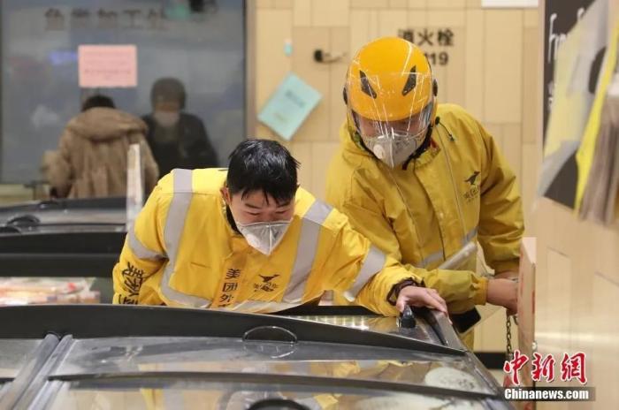 资料图:2月7日,浙江杭州,两位外卖派送人员戴着口罩在超市取货。/p中新社记者 王伟臣 摄