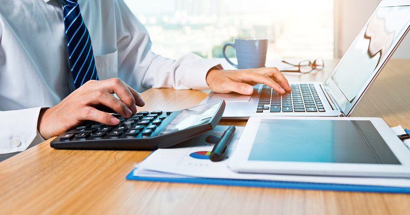 在办公室里使用数字平板电脑和笔记本电脑的商人图片下载