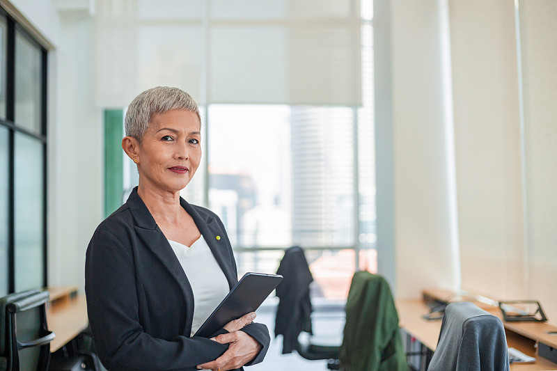 办公室里有平板电脑的资深女商人图片下载