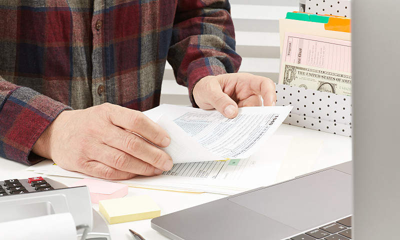 一个拿着税单的男人特写图片下载