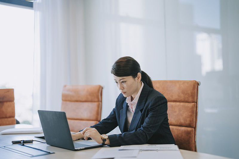 亚裔华裔女经理在会议室里用笔记本电脑专心工作，阅读电子邮件图片下载