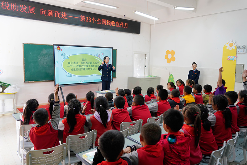 课堂互动环节，学生们纷纷举手抢答税务干部提出的税法、税收相关知识点-（曾超-摄）